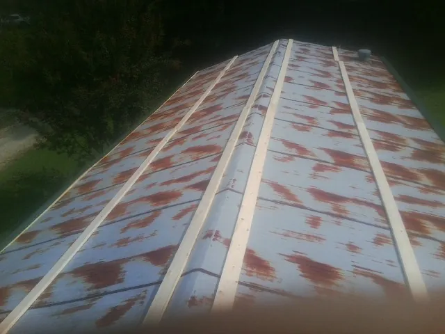 Rusted metal roof panels with new wood purlins before replacement — Storm Damage Roof Repair in Beale Afb by Roofing Brothers