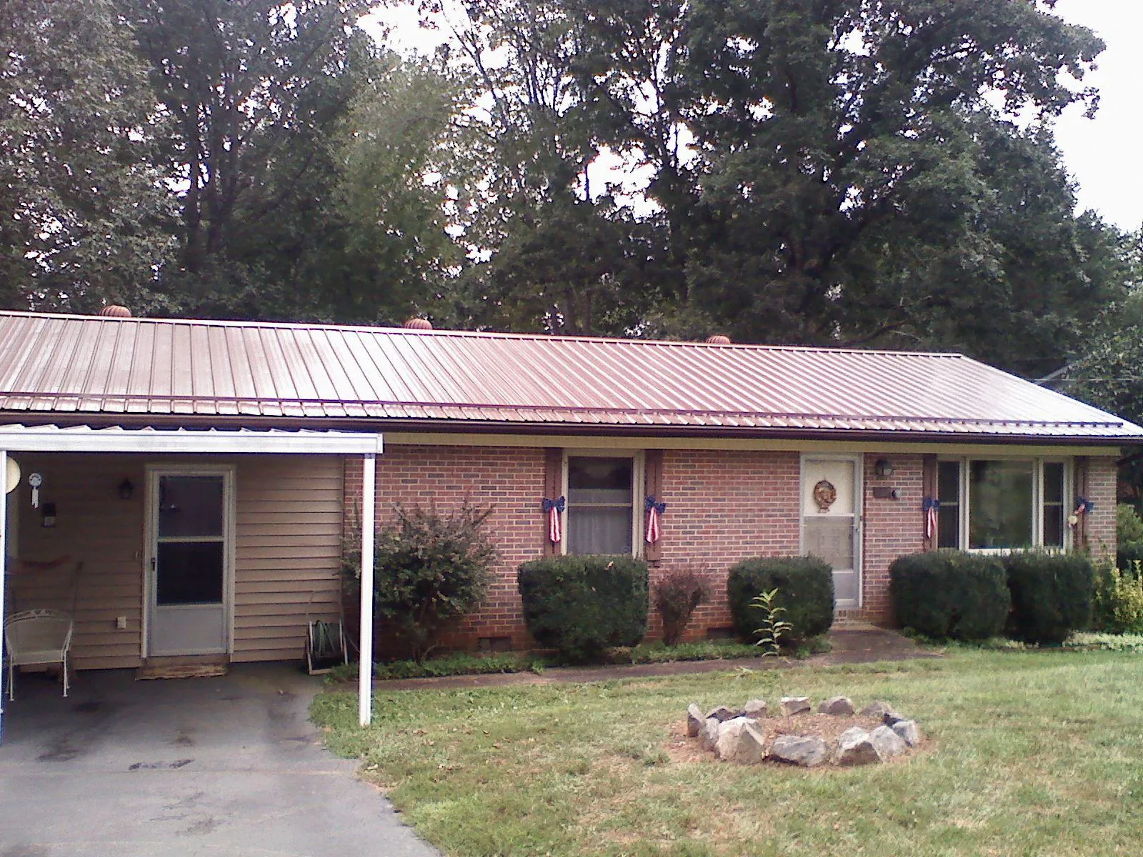Bronze metal roof and carport on a brick ranch home — Roof Repair work by our crew in Beale Afb